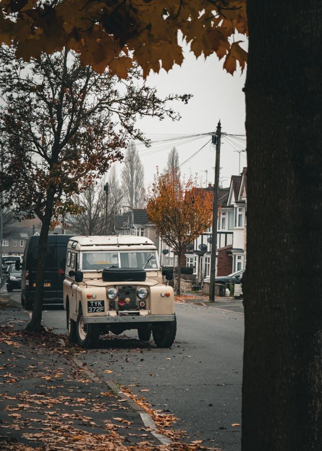 An old SUV on an autumn covered street